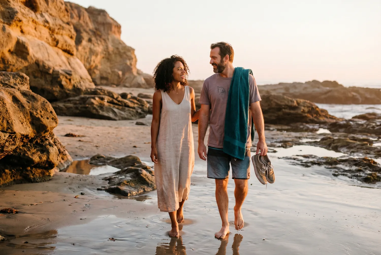 Couple walking a Corona del Mar cove at sunset in Newport Beach