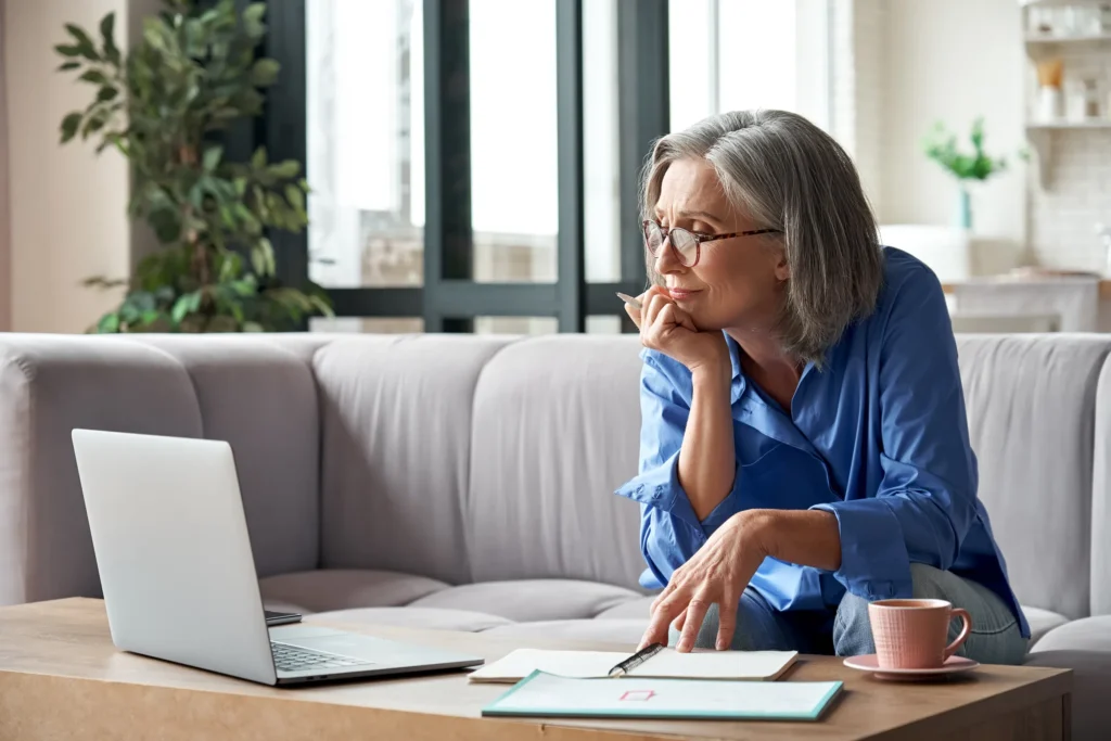 lady looking at computer with notebook in front of her