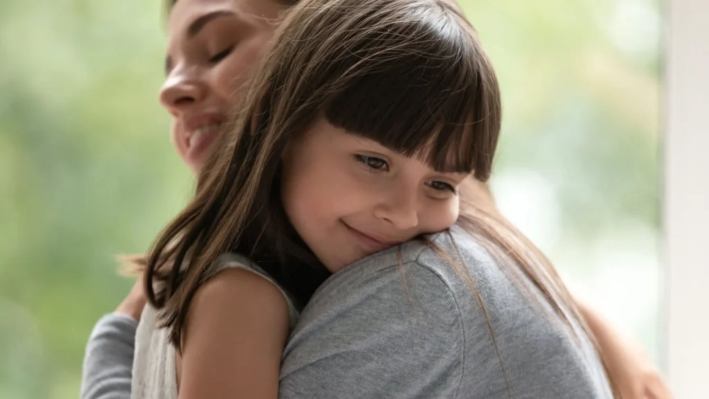 mother holding daughter on her chest / shoulder