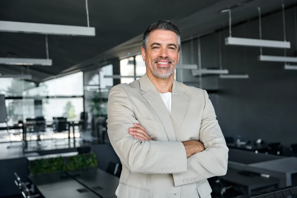 professionally dressed man smiling in a work environment