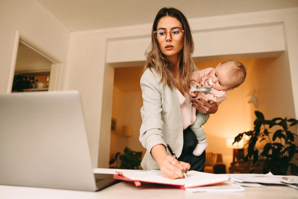 young professional mother working while holding her baby