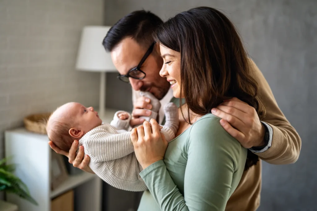 couple smiling and showing affection to baby