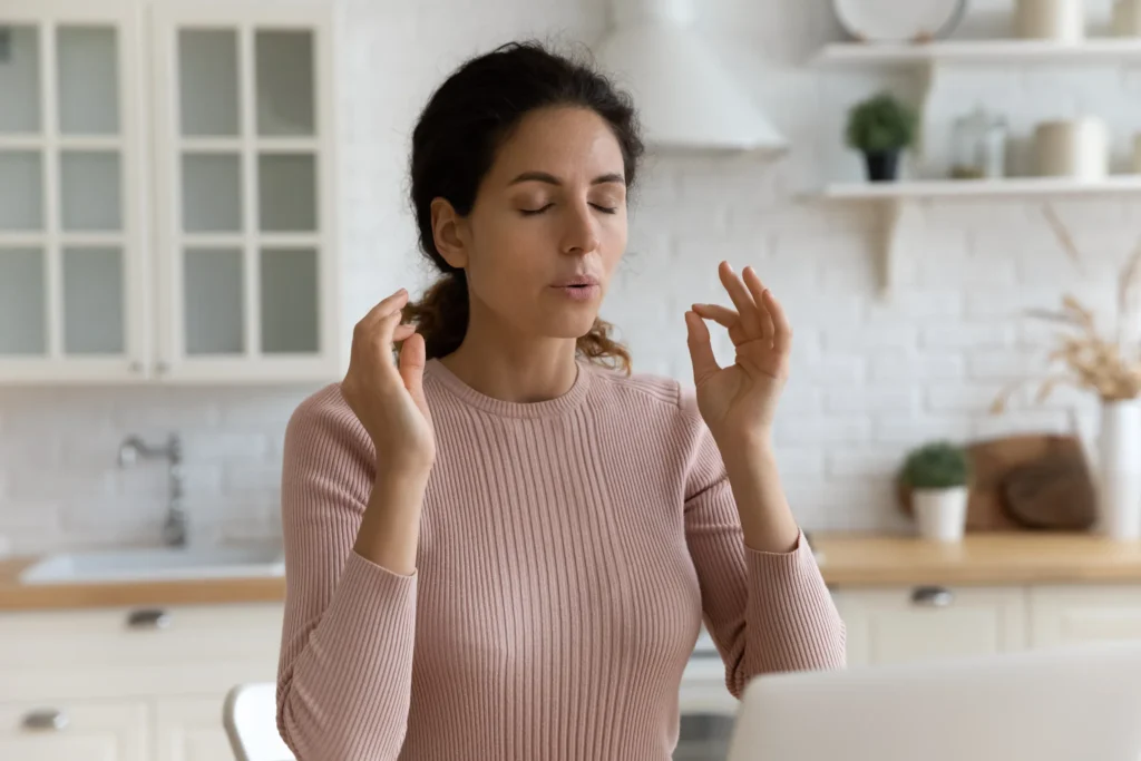 woman taking a moment to breath while sitting at desk