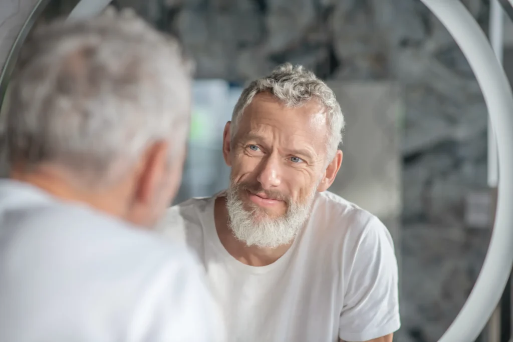 middle aged man staring at mirror