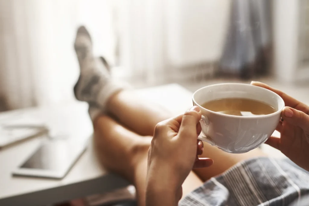 cup of tea and feet propped onto coffee table