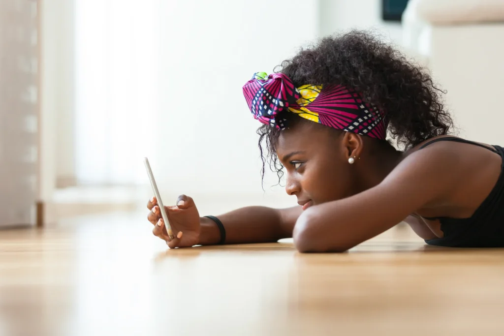 young woman on floor staring at her phone