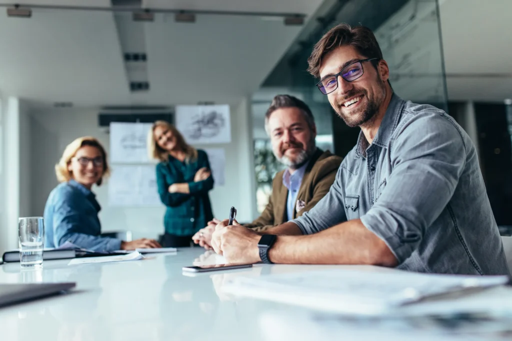 group of business professionals in a meeting smiling for the camera