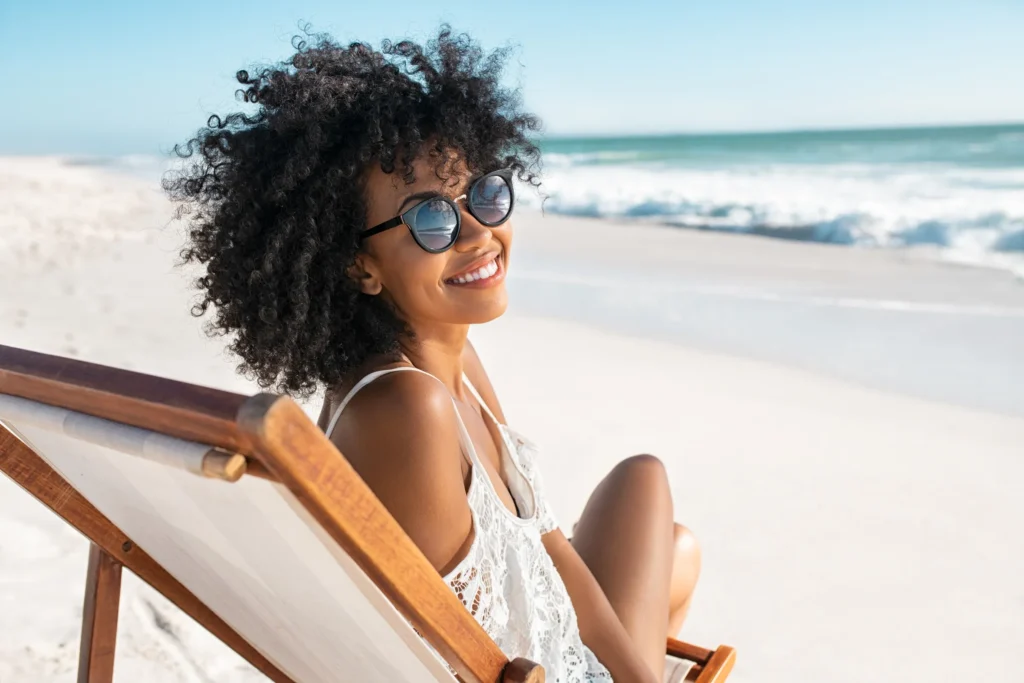 woman smiling and sitting on a beach chair