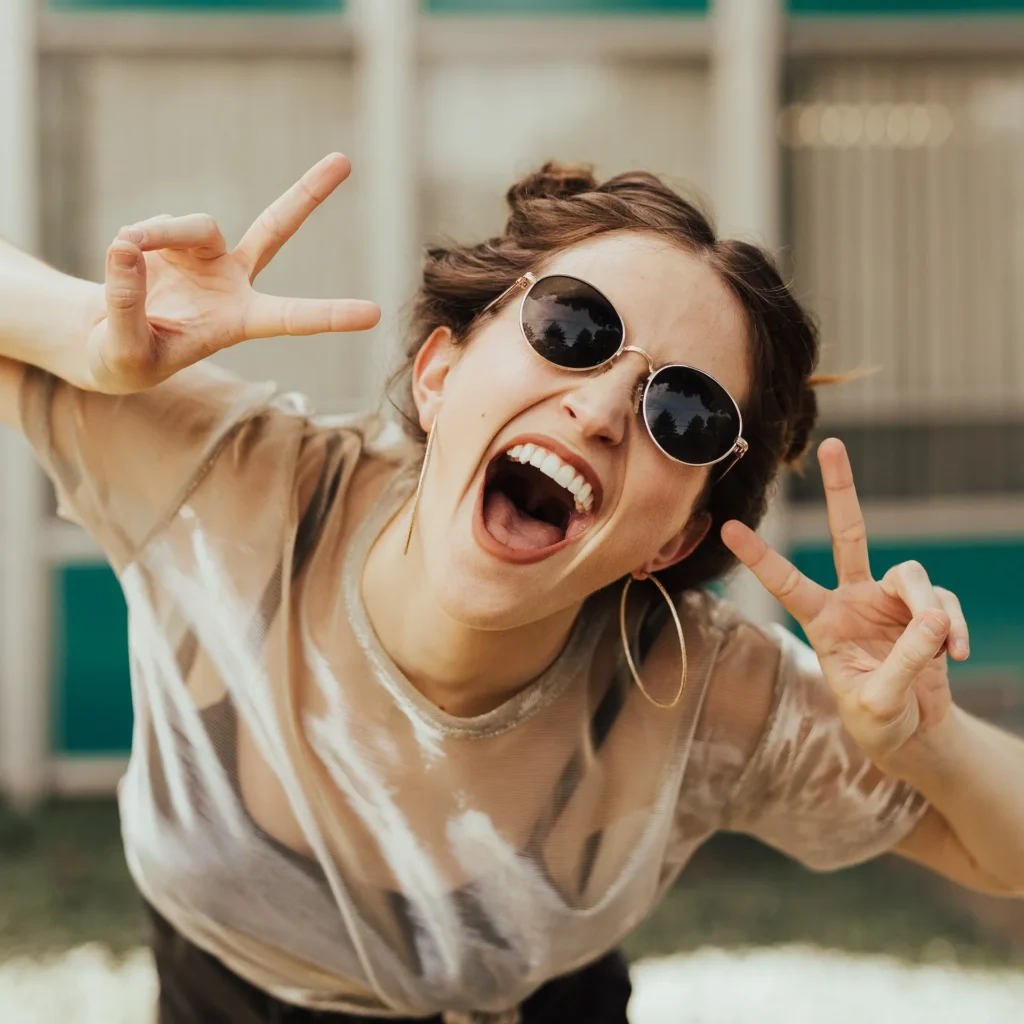 girl smiling holding peace signs