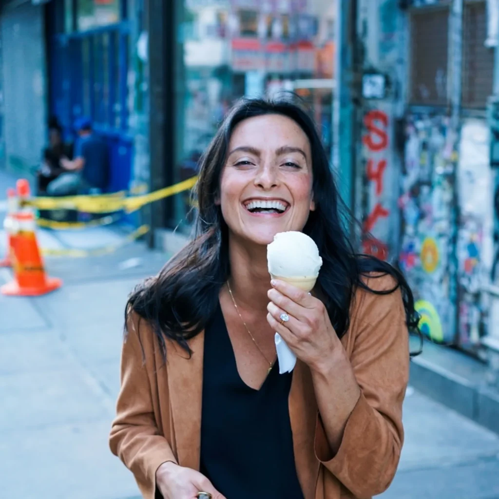 woman eating an icecream cone in urban area